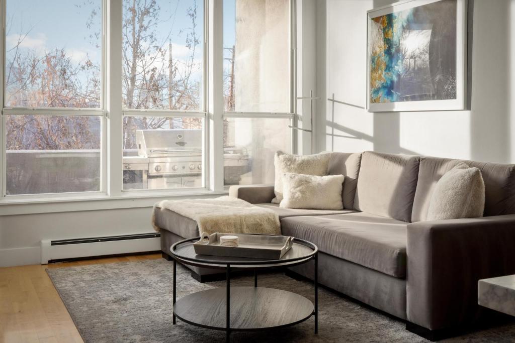 ein Wohnzimmer mit einem Sofa und einem Tisch in der Unterkunft Chic City Park Home - Rooftop Deck - Skyline Views in Denver