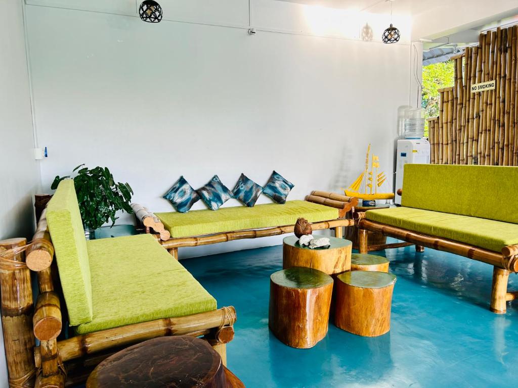 a living room with couches and tables and a person sitting on a table at Bhūma in Havelock Island
