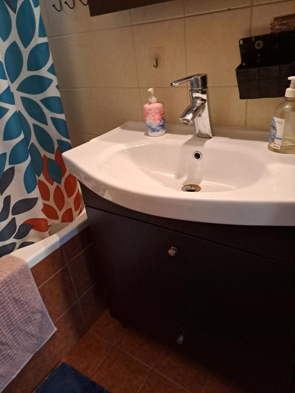 La salle de bains est pourvue d'un lavabo blanc et d'un miroir. dans l'établissement Hera Apartment, à Alexandroúpolis