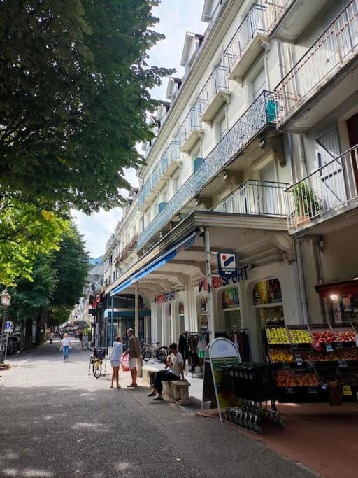Un groupe de personnes marchant dans une rue à côté d'un bâtiment dans l'établissement Appartement 5 personnes centre de Luchon, à Luchon