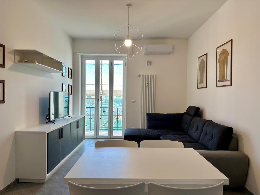 ein Wohnzimmer mit einem Sofa und einem Tisch in der Unterkunft Casa Maestrale - Elegante con Balcone Vista Mare in Finale Ligure