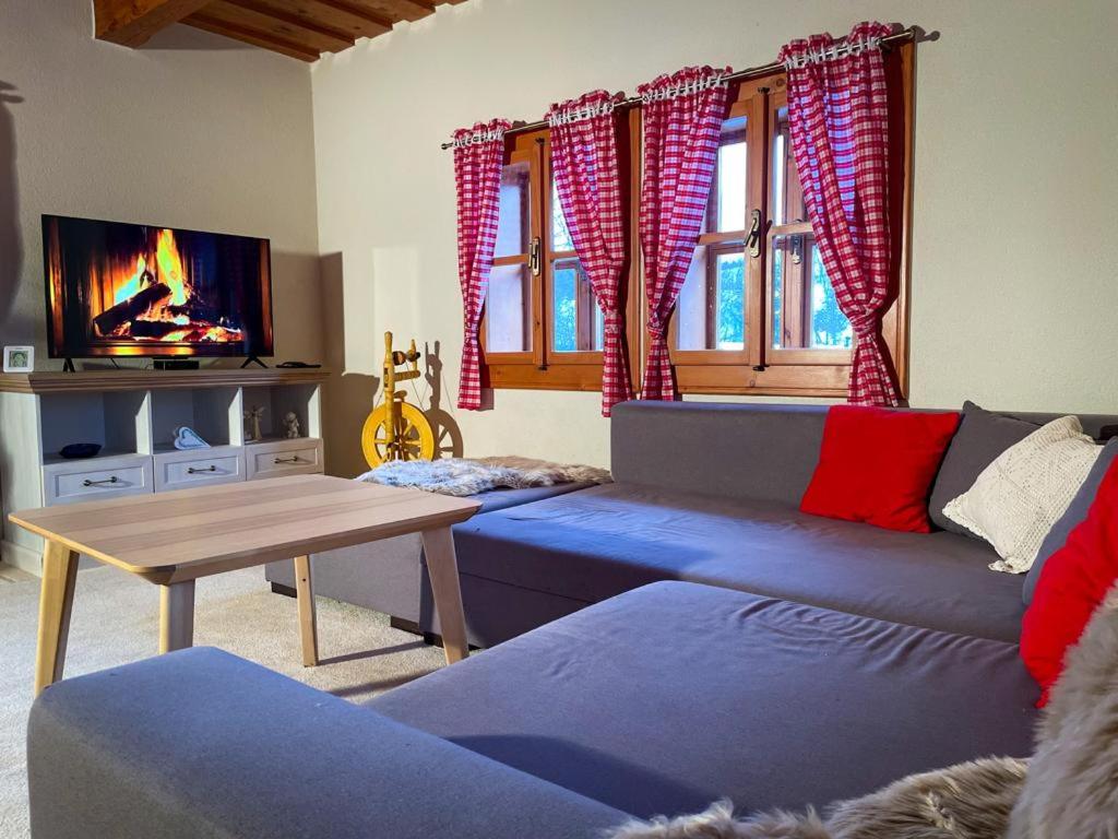 a living room with a blue couch and a tv at Traditional deer Cabin with Sauna in Dolný Kubín