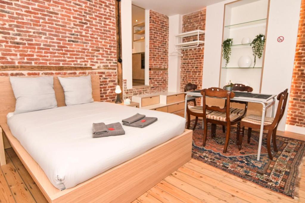a bedroom with a bed and a dining table at Dream duplex near the Royal Palace - city center in Brussels