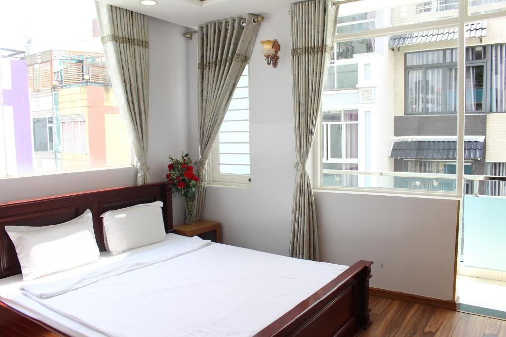 a bedroom with a bed and a large window at Sunny Guesthouse in Ho Chi Minh City