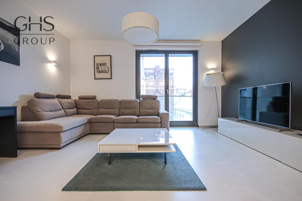 uma sala de estar com um sofá e uma televisão em Ekskluzywny Apartament obok Zamku Wawelskiego em Cracóvia