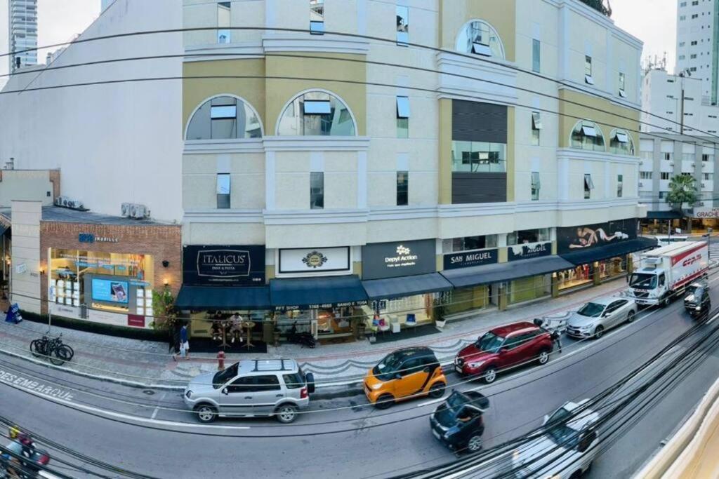 a street with cars parked in front of a building at Conforto e a melhor localização in Balneário Camboriú