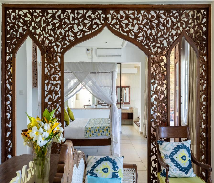 a bedroom with a bed and a table and chairs at Hillpark Amare Resort in Tiwi