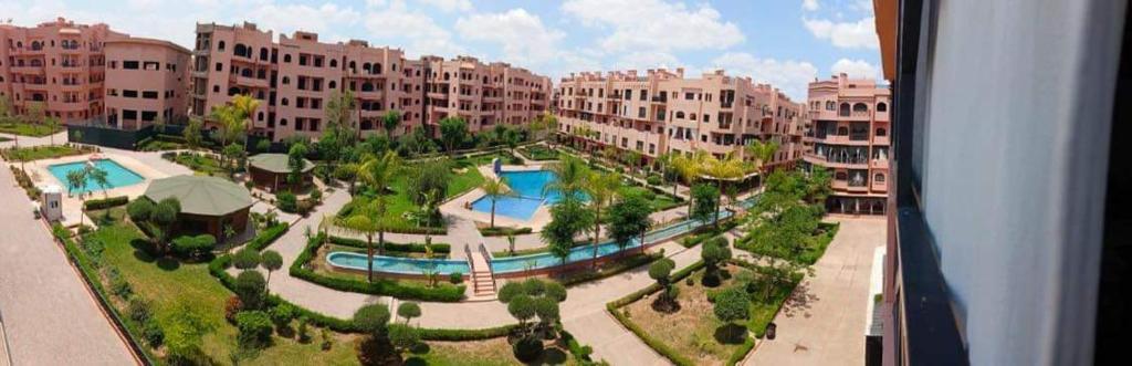 une vue aérienne d'un complexe hôtelier avec piscine dans l'établissement Appartement Ensoleillé vue Piscine, à Marrakech