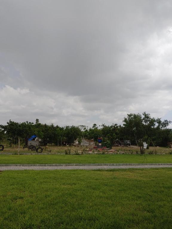 Mbuguni的住宿－Shelta Village View Resort，远处有一条路的草地
