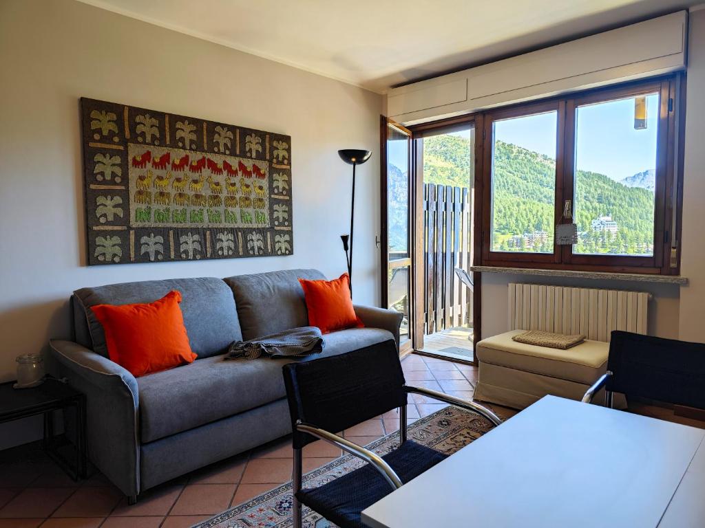 a living room with a couch and a table at Hostdomus -Pastore Apartment in Sestriere