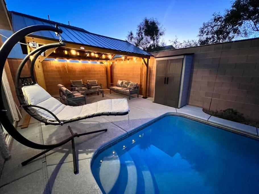 a swimming pool with a chair and a couch at Family Friendly Contemporary House with Pool in Las Vegas