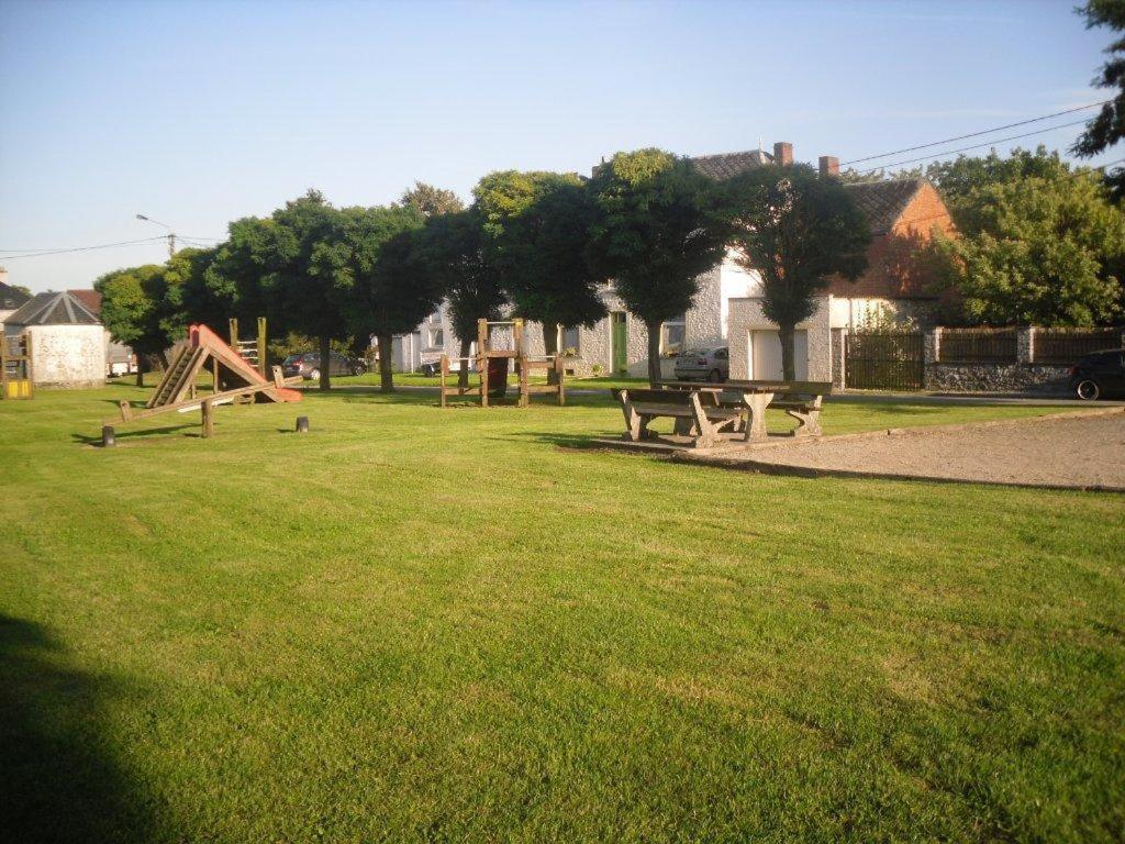 un parc avec une table de pique-nique et des bancs dans l'herbe dans l'établissement B&B La Place Verte, à Surice