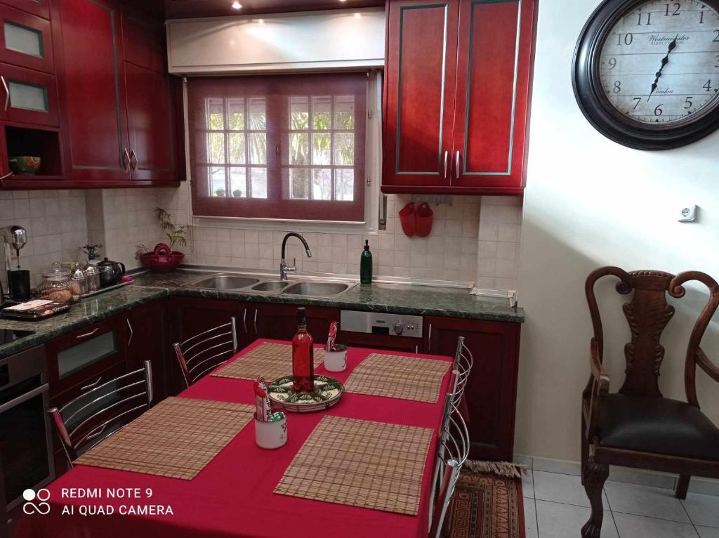kuchnia ze stołem i zegarem na ścianie w obiekcie ΤΣΙΤΣΑΝΗ 167 w mieście Tríkala