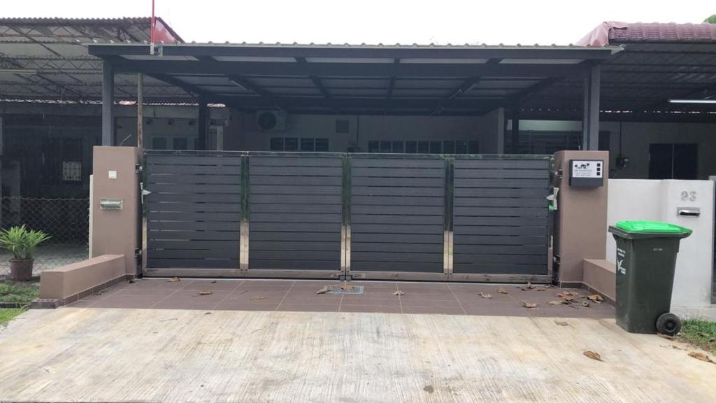 a garage with a fence and a trash can at Modern 3 bedrooms House, Walking distance to Kulim Town by Mr Homestay in Kulim