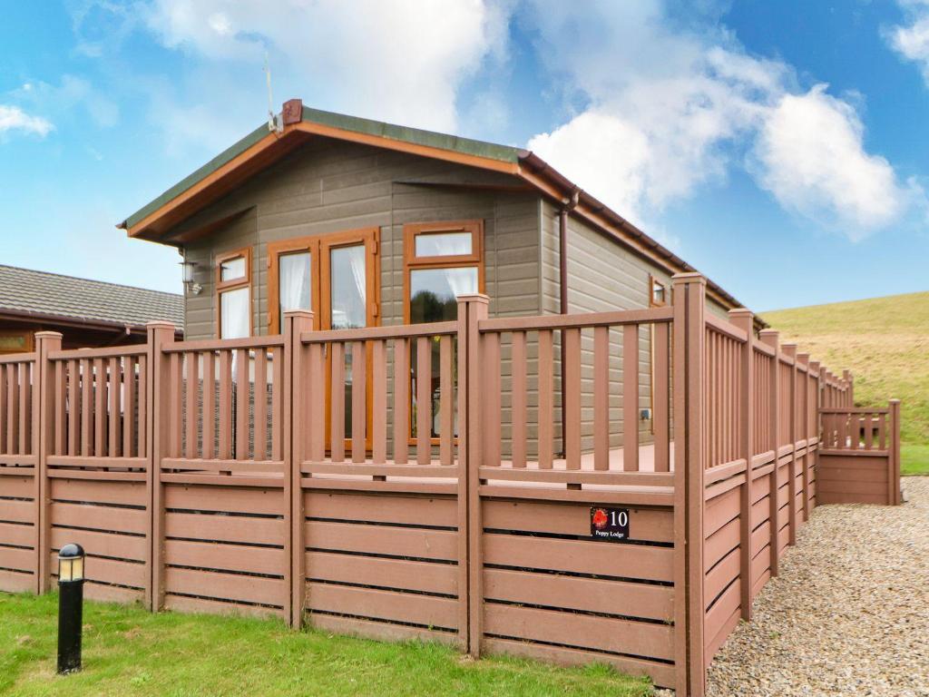 a small house with a wooden fence at 10 Poppy Lodge in Richmond