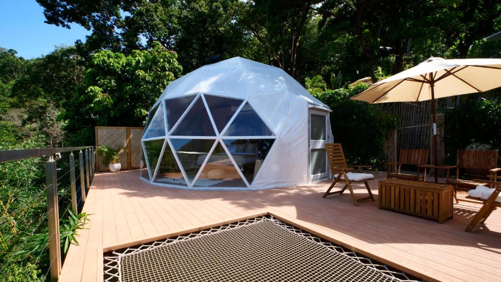 愛妮島的住宿－Unique Stays at Karuna El Nido - The Dome，甲板上的帐篷,配有桌子和遮阳伞