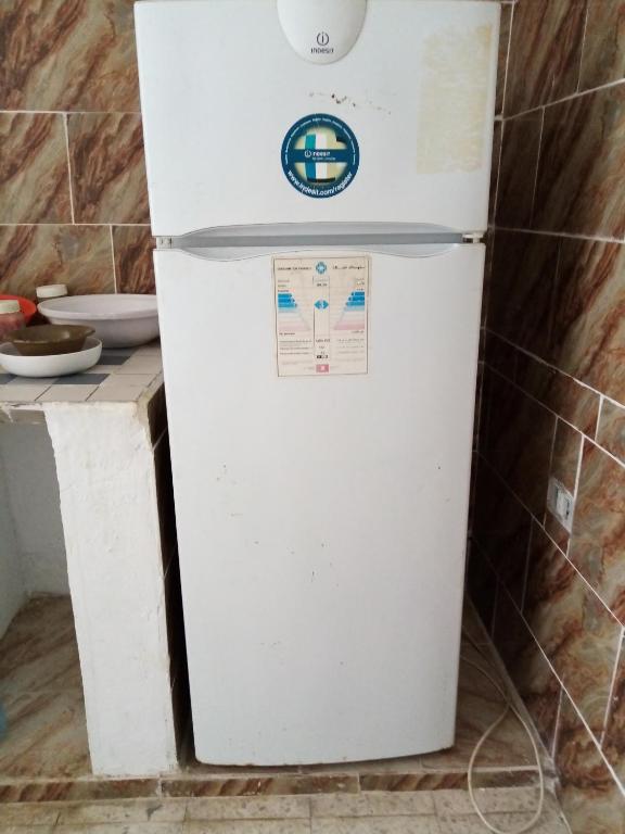 un frigorifero bianco seduto in una cucina accanto a un bancone di Venus house15 a Raoued