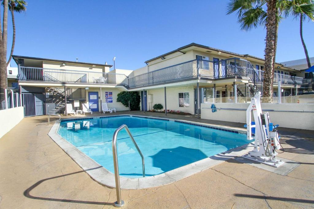 a swimming pool in front of a house at Motel 6 San Diego, CA Airport Harbor in San Diego