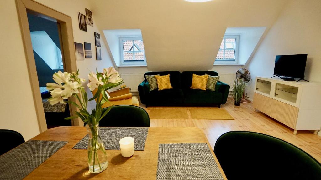 una sala de estar con una mesa con un jarrón de flores en Klimatyczny przy Św. Barbary, en Olsztyn