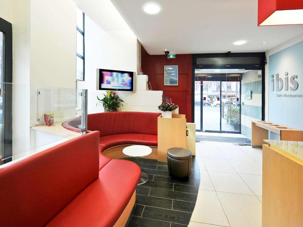 sala de estar con sofá rojo y mesa en Ibis Paris Gare Montparnasse 15ème, en París