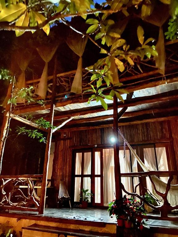 a log cabin with a window and a tree at Casa El Alux Campestre in Macario Gomez