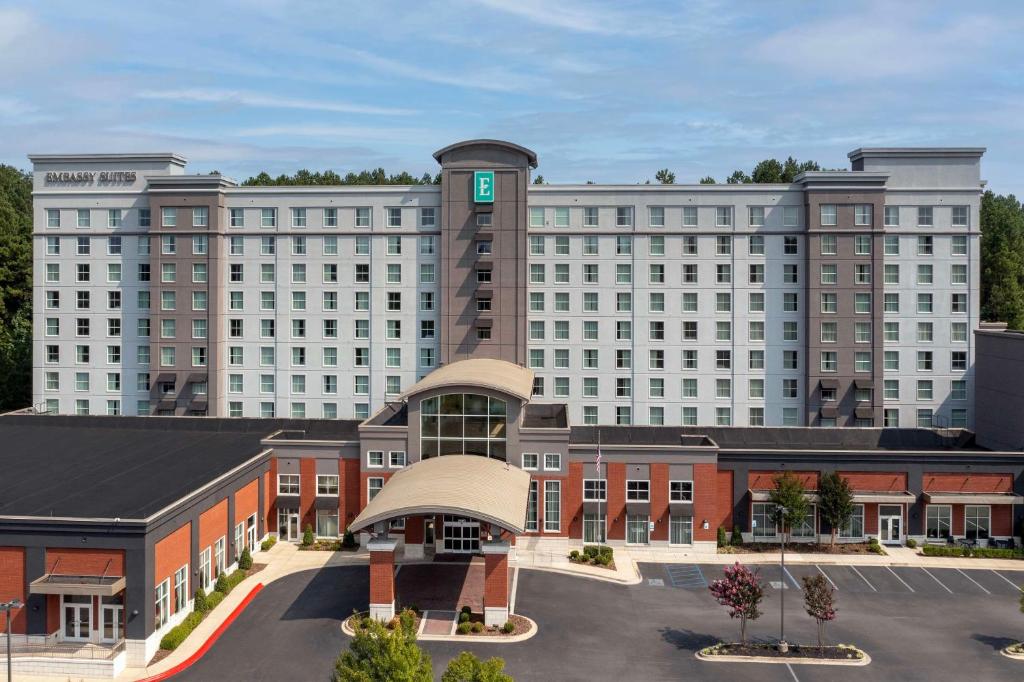 Embassy Suites by Hilton Birmingham Hoover في هوفر: مبنى كبير وامامه موقف سيارات