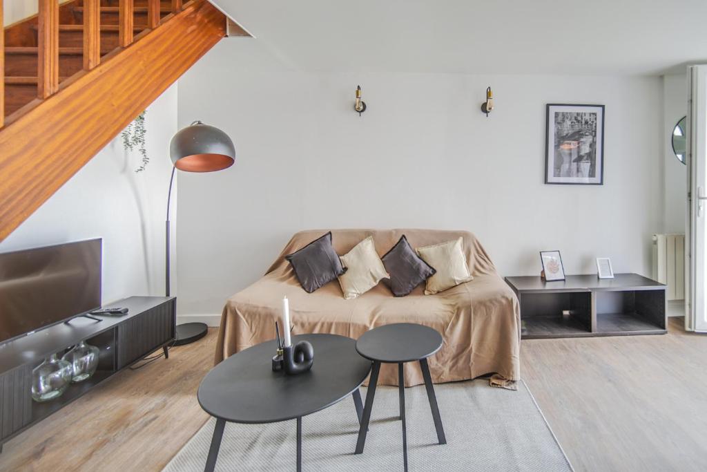 un salon avec un canapé et une table dans l'établissement Le 2en1 Roissy CDG, à Longperrier