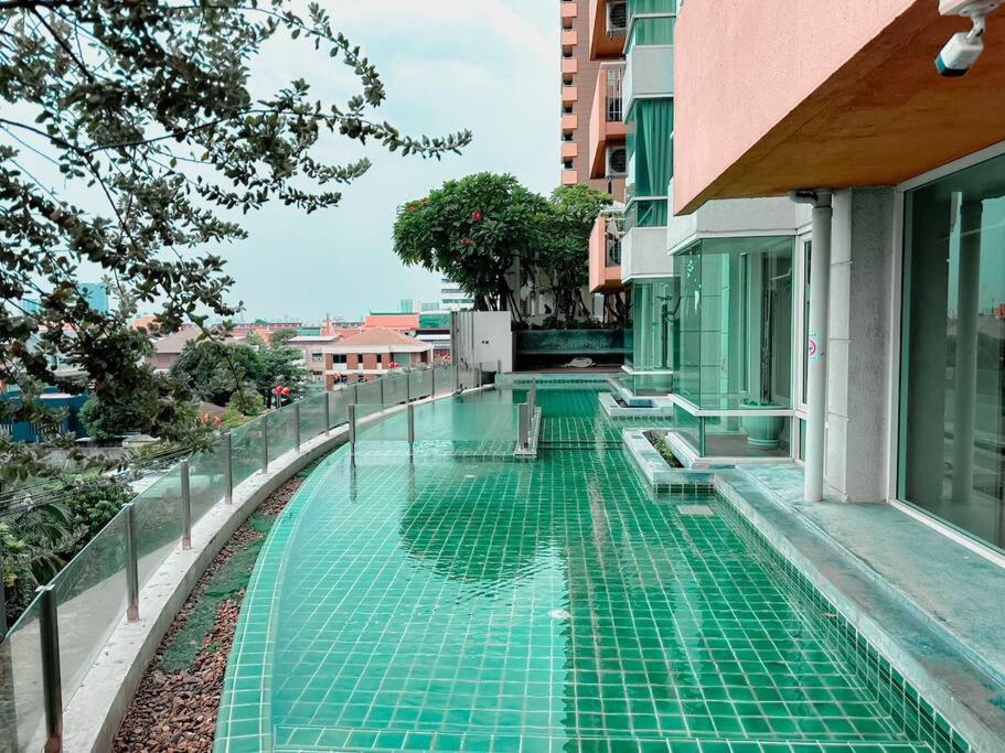 a swimming pool on the side of a building at 2Bedroom, WiFi, washing machine and small kitchen in Pak Kret