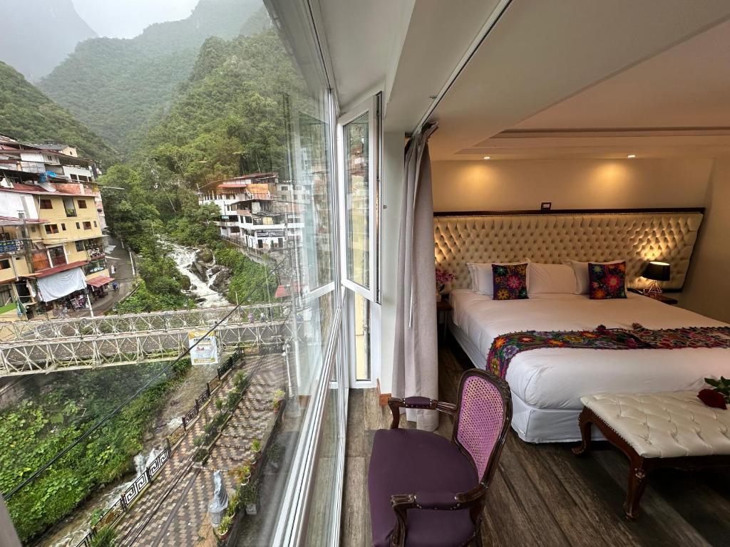 a hotel room with two beds and a large window at Jaya Machu Picchu Boutique Hotel in Machu Picchu