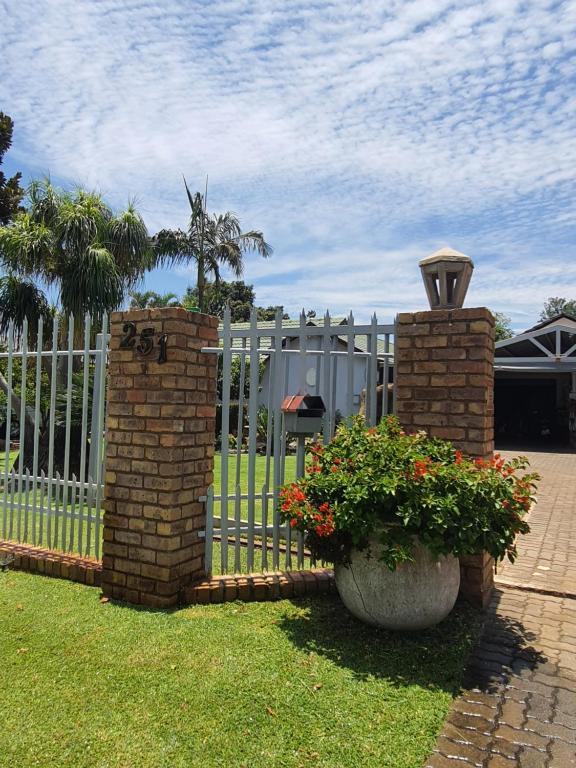 a fence with a flower pot in a yard at Jean Michael Self-catering apartment for stay overs in Pretoria