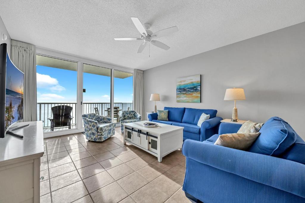 una sala de estar con muebles azules y vistas al océano. en Majestic Beach Towers 2-1701 en Panama City Beach