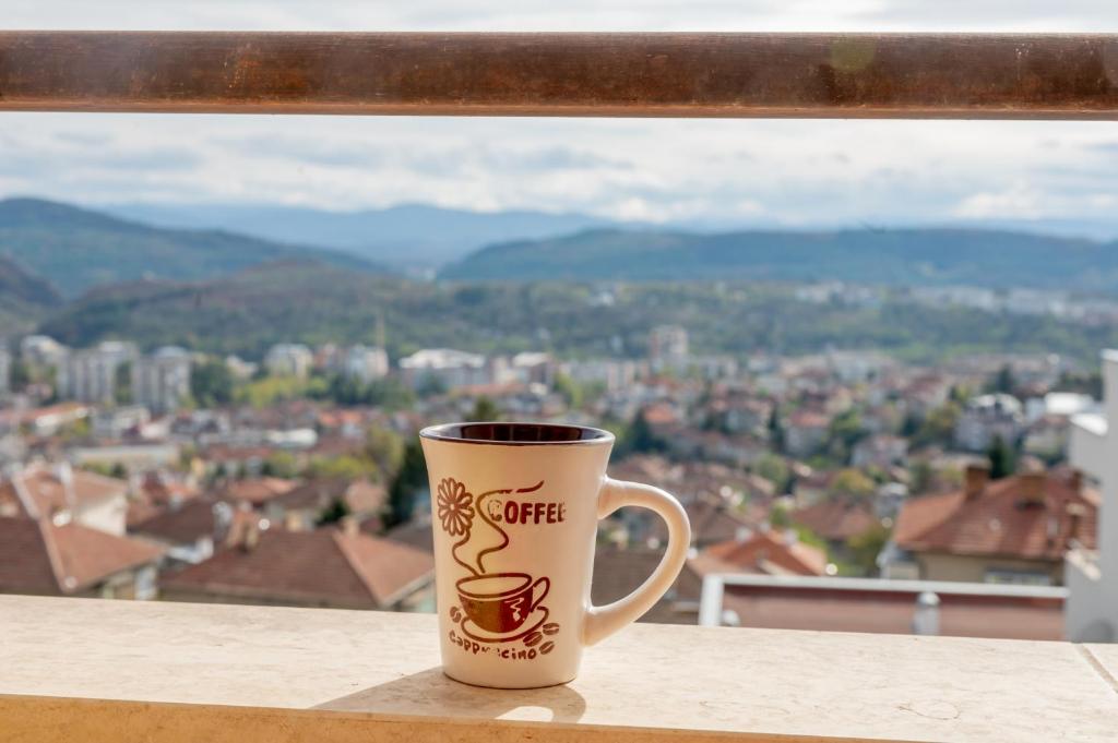 大特爾諾沃的住宿－Апартамент Панорама，坐在窗前桌子上的咖啡杯