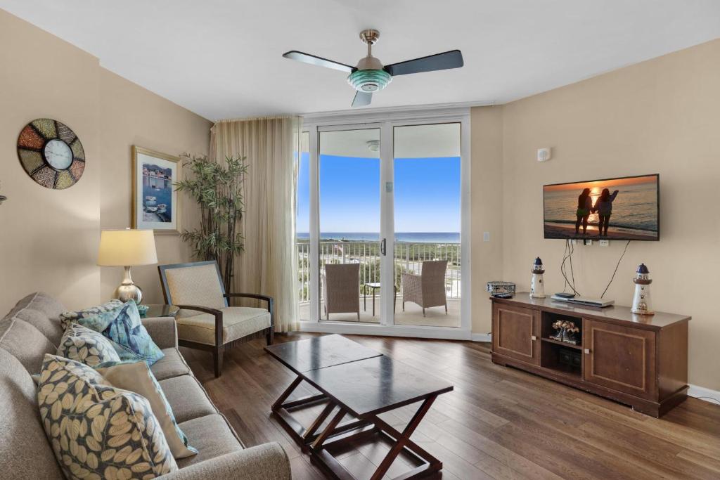 ein Wohnzimmer mit einem Sofa, einem TV und einem Tisch in der Unterkunft Palms Resort #1814 Jr. 2BR in Destin