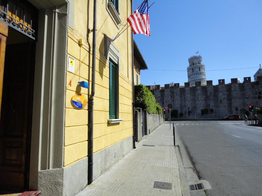Hostel Pisa Tower في بيزا: مبنى مع العلم الامريكي على جانب شارع