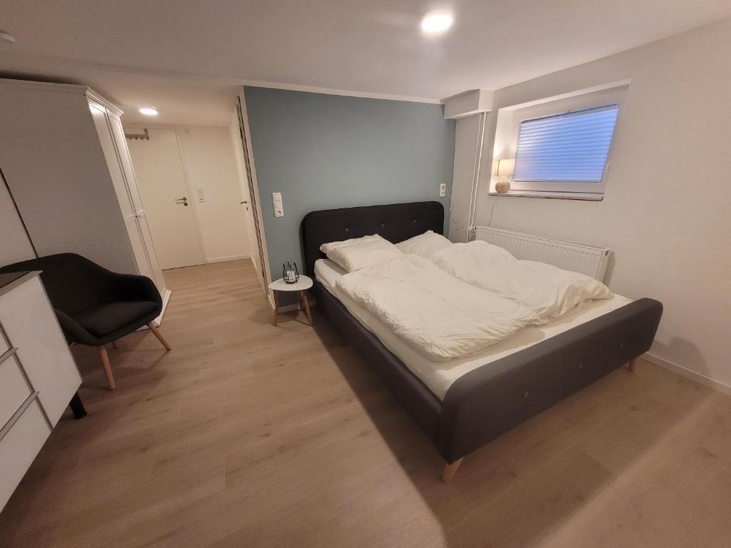 1 dormitorio con 1 cama, 1 silla y 1 ventana en Zimmer im Souterrain mit eigenem Bad, en Celle