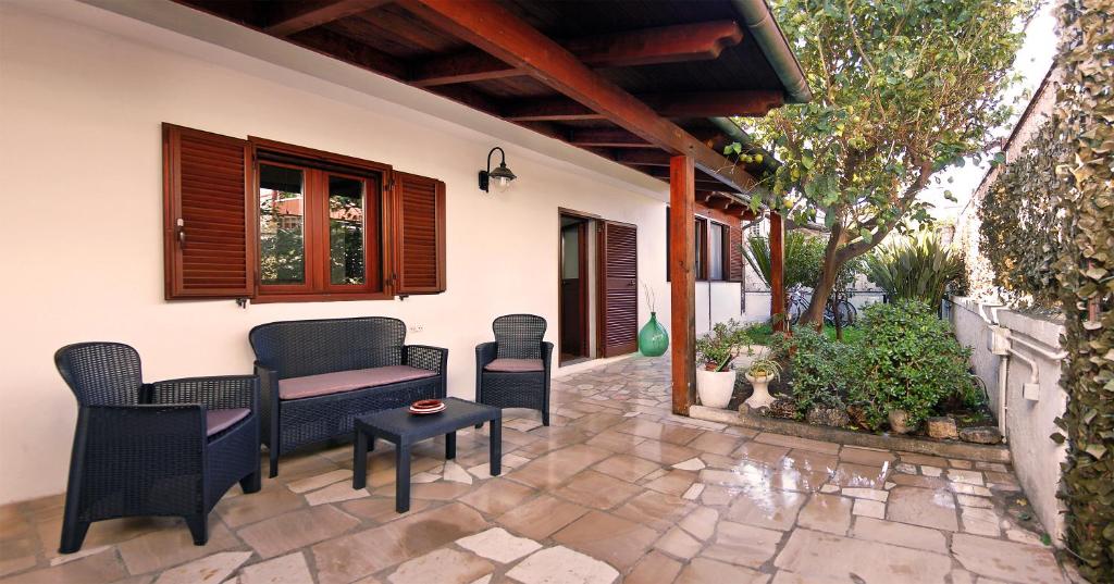 eine Terrasse mit Stühlen, einem Tisch und einem Fenster in der Unterkunft Sea breeze Villa - Luna apartment in Bari Palese