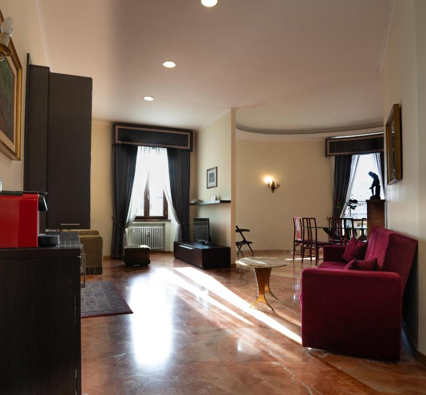 sala de estar con sofá rojo y mesa en Le Cupoline, en Roma