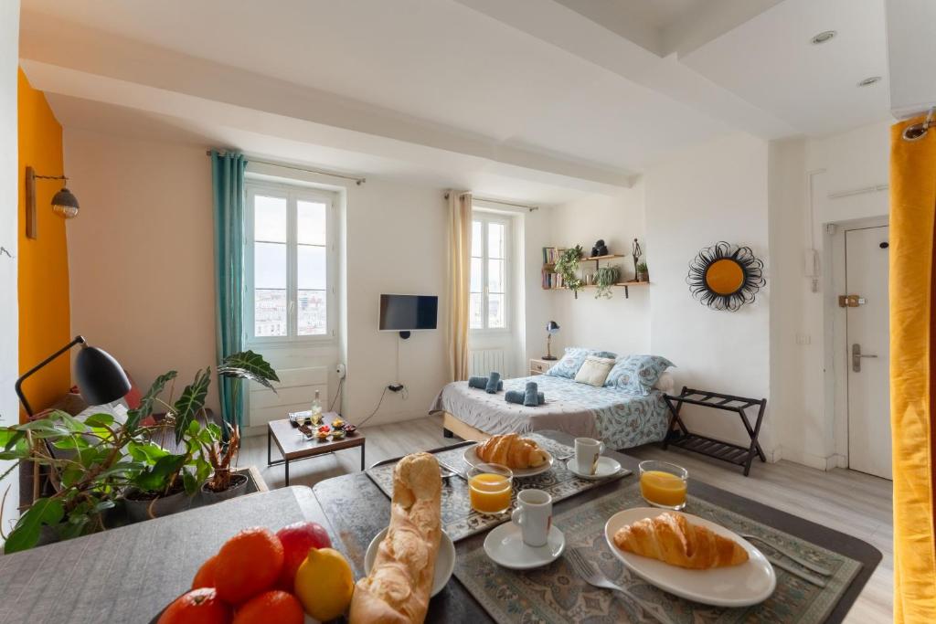 - un salon avec un lit et une table avec de la nourriture dans l'établissement STUDIO VIEUX-PORT VUE BASILIQUE NOTRE-DAME, à Marseille