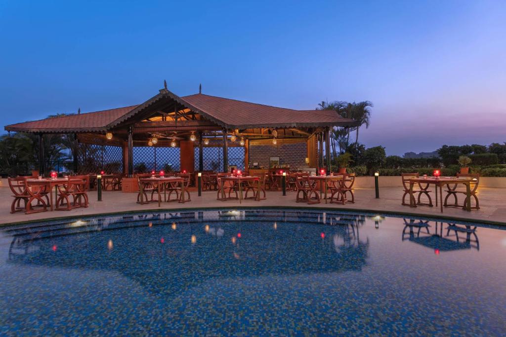 浦那的住宿－Sheraton Grand Pune Bund Garden Hotel，池畔凉亭配有桌椅