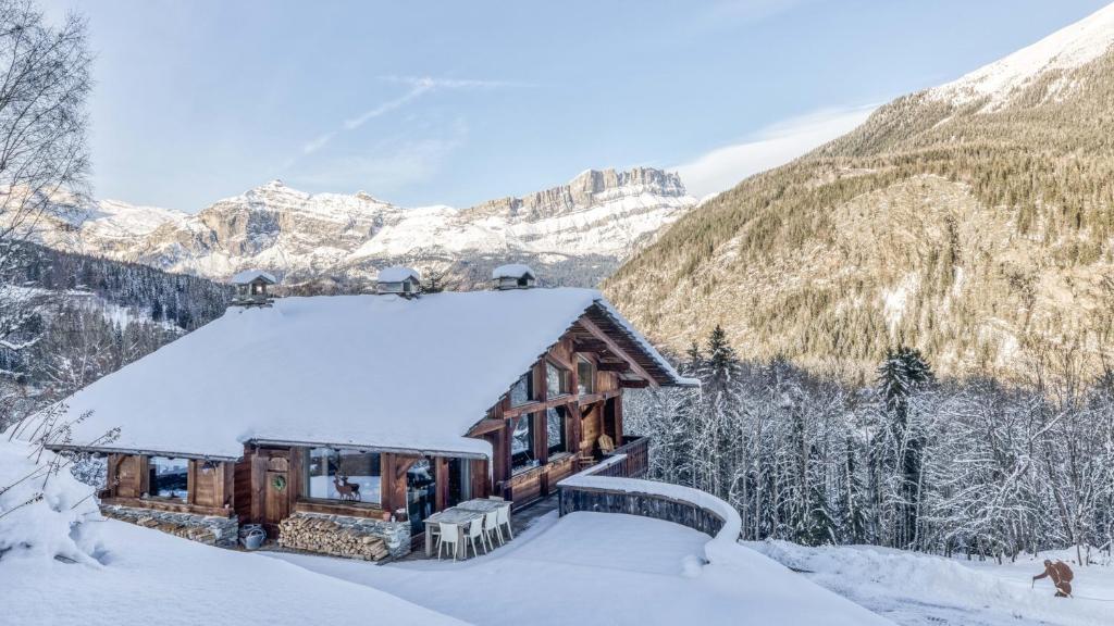 une cabane en rondins dans les montagnes recouvertes de neige dans l'établissement Chalet Castor, aux Houches