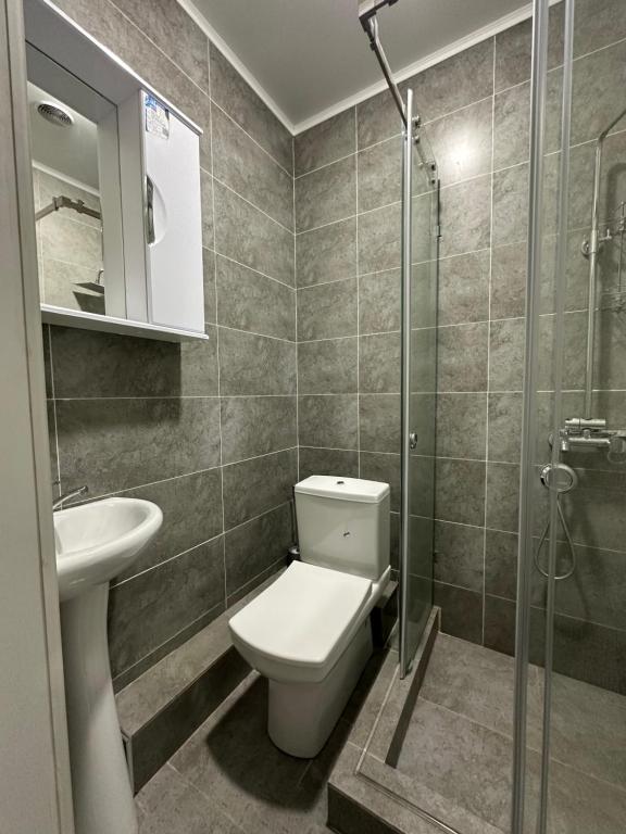 une salle de bain avec toilettes, lavabo et douche dans l'établissement Holiday house Bishkek, à Bishkek