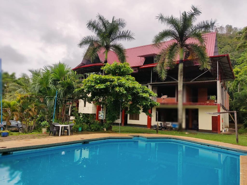 a house with a swimming pool in front of a building at Paraiso Inn in Satipo
