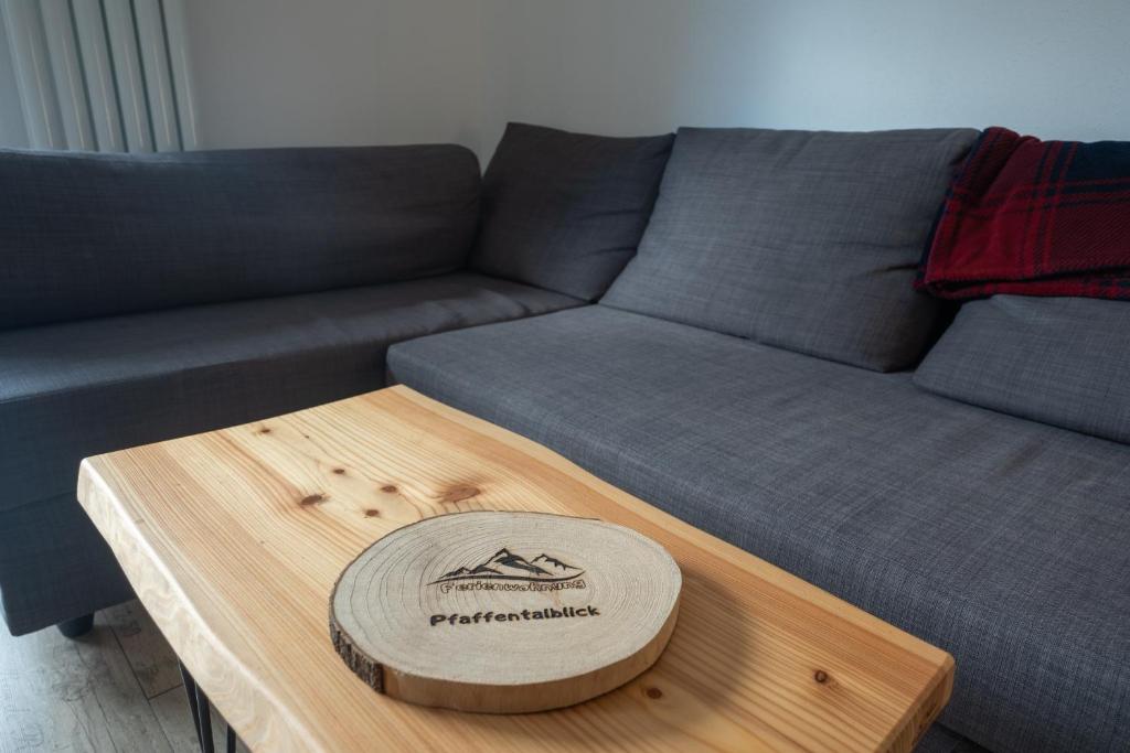 a couch with a wooden coffee table with a hat on it at Ferienwohnung Pfaffentalblick in Zella-Mehlis