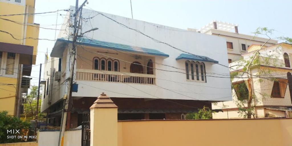 a white building with windows on a city street at Meera Guest House,Cuttack in Cuttack