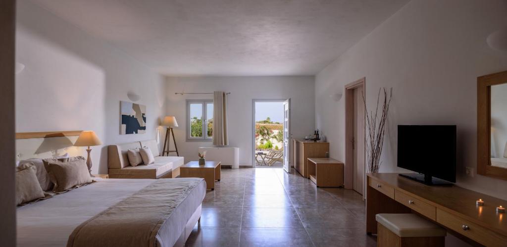 a hotel room with a bed and a television at Aliter Suites in Fira