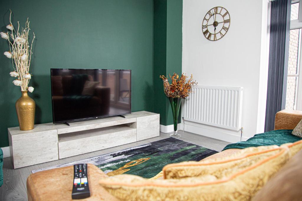 a living room with a flat screen tv on a entertainment center at Modern and Stylish 1 Bed Flat in High Wycombe