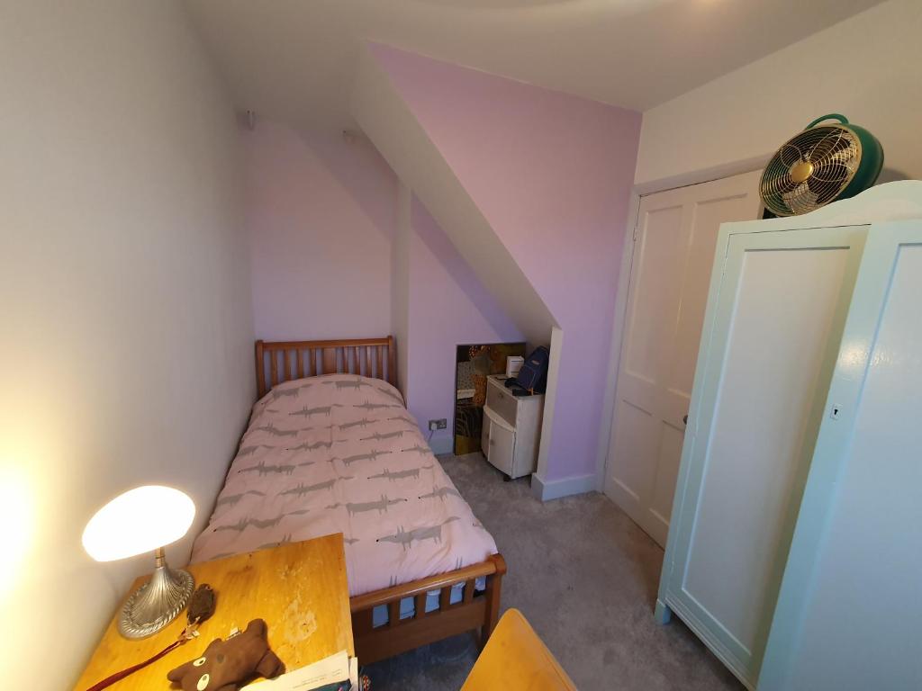 una piccola camera con letto e tavolo di Lotus Pod House Homestay a Horsell