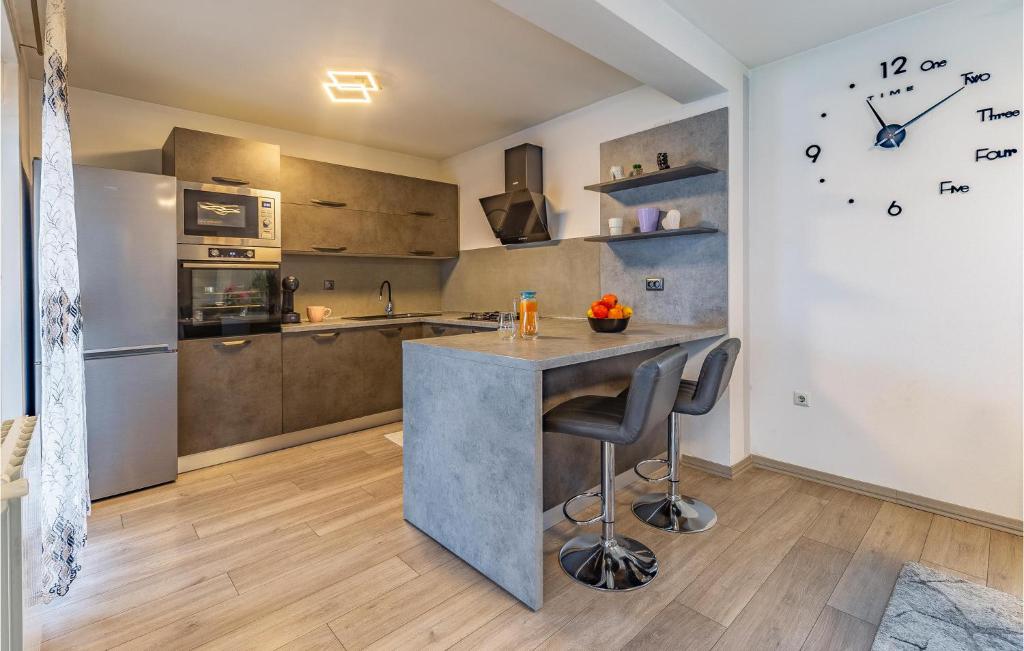 a kitchen with a counter and a large clock on the wall at Beautiful Home In Skatari With Outdoor Swimming Pool in Škatari