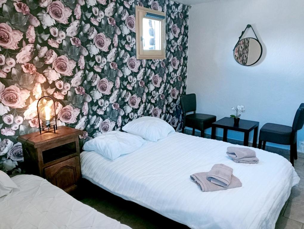 une chambre avec deux lits et un mur floral dans l'établissement Õ 2040 Chambre Sapin, à Saint-Véran