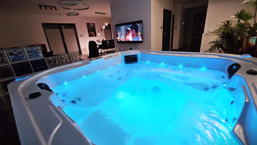 una grande vasca idromassaggio in una camera con TV di Komfortowy dom z jacuzzi blisko Trójmiasta a Banino